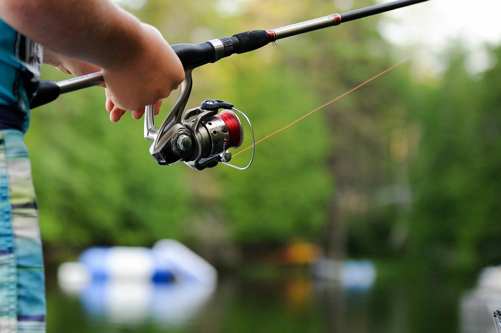 Man holding silver fishing rod
